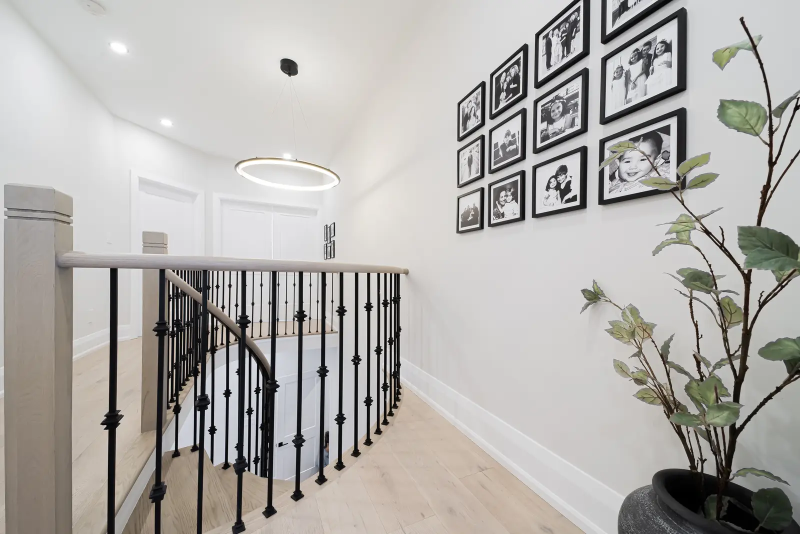 Interior of a Thornhill detached house renovation, with pale wood floors, black furnishings, and a walnut vanity in the primary bathroom.