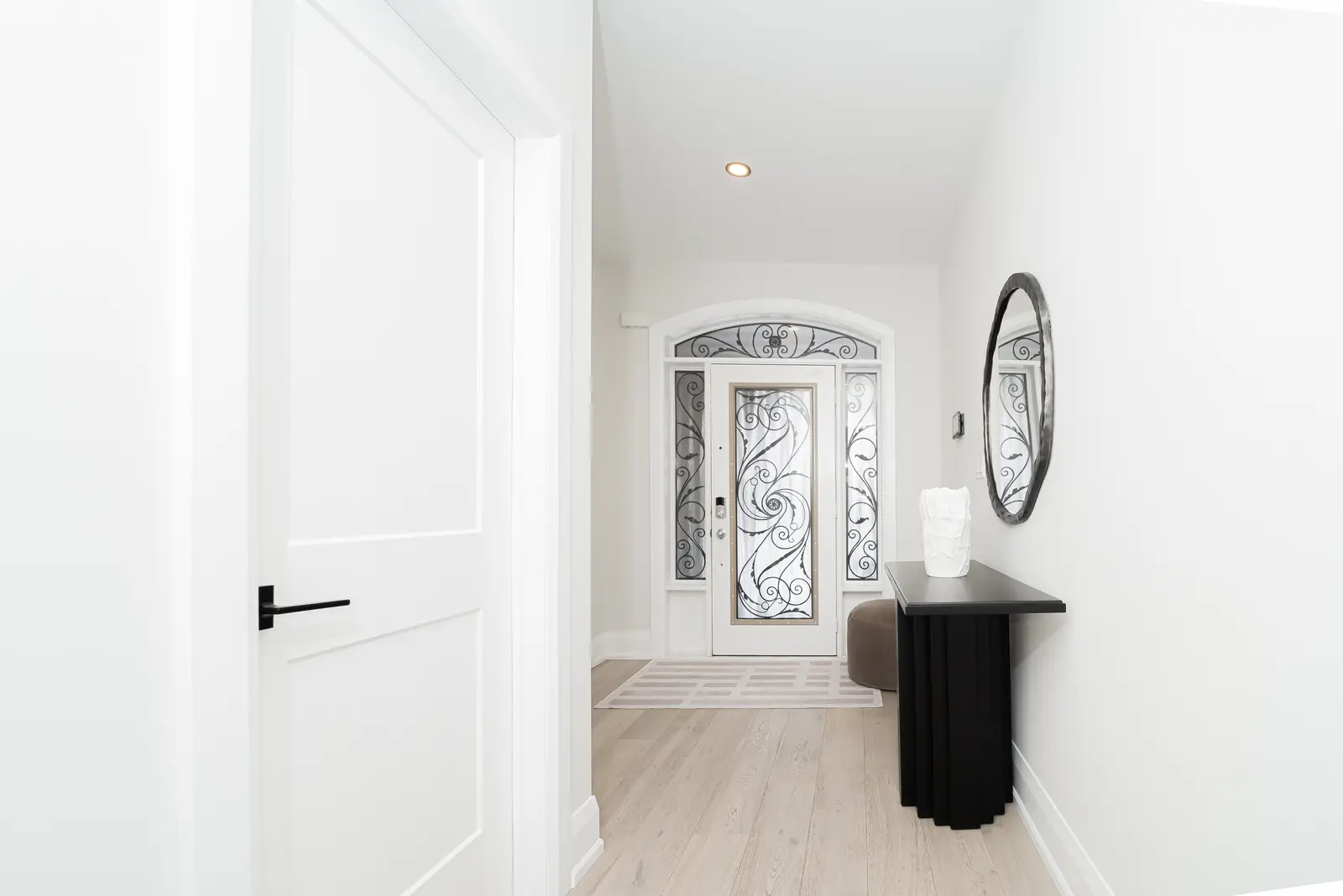 Interior of a Thornhill detached house renovation, with pale wood floors, black furnishings, and a walnut vanity in the primary bathroom.
