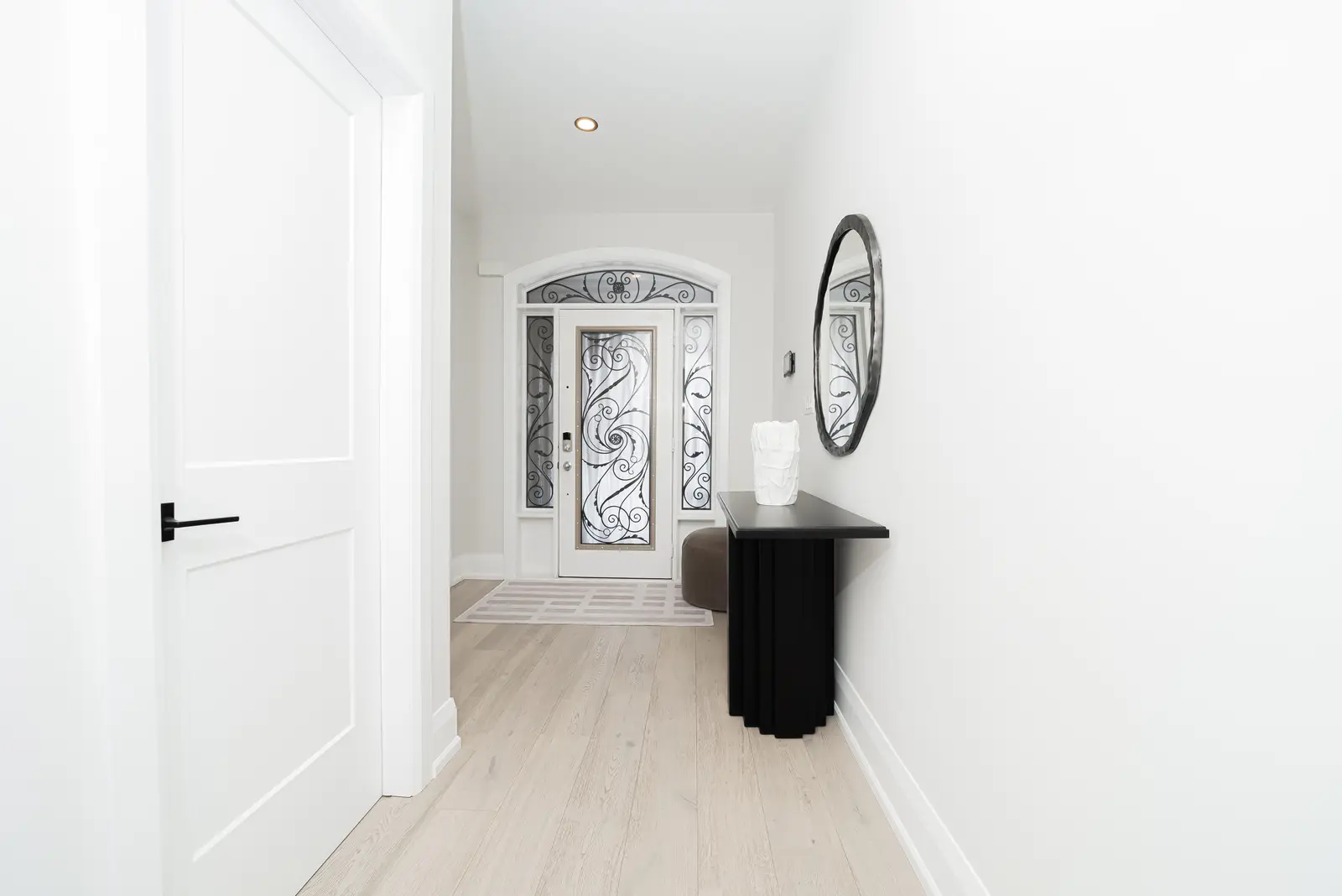 Interior of a Thornhill detached house renovation, with pale wood floors, black furnishings, and a walnut vanity in the primary bathroom.