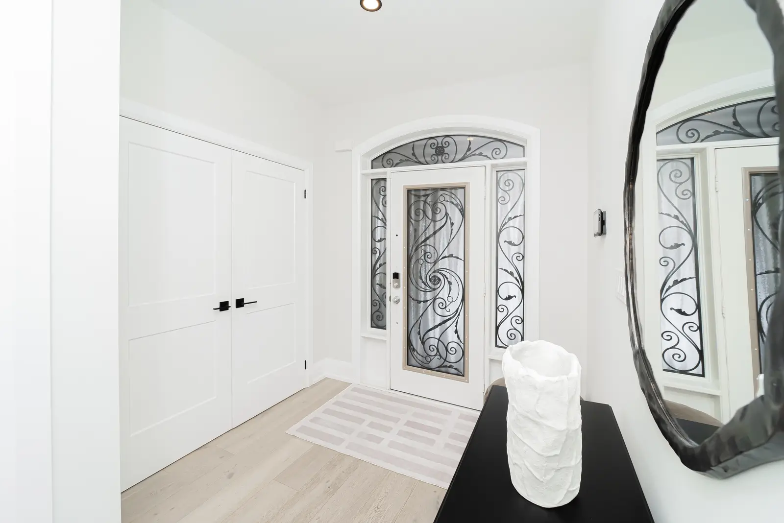 Interior of a Thornhill detached house renovation, with pale wood floors, black furnishings, and a walnut vanity in the primary bathroom.