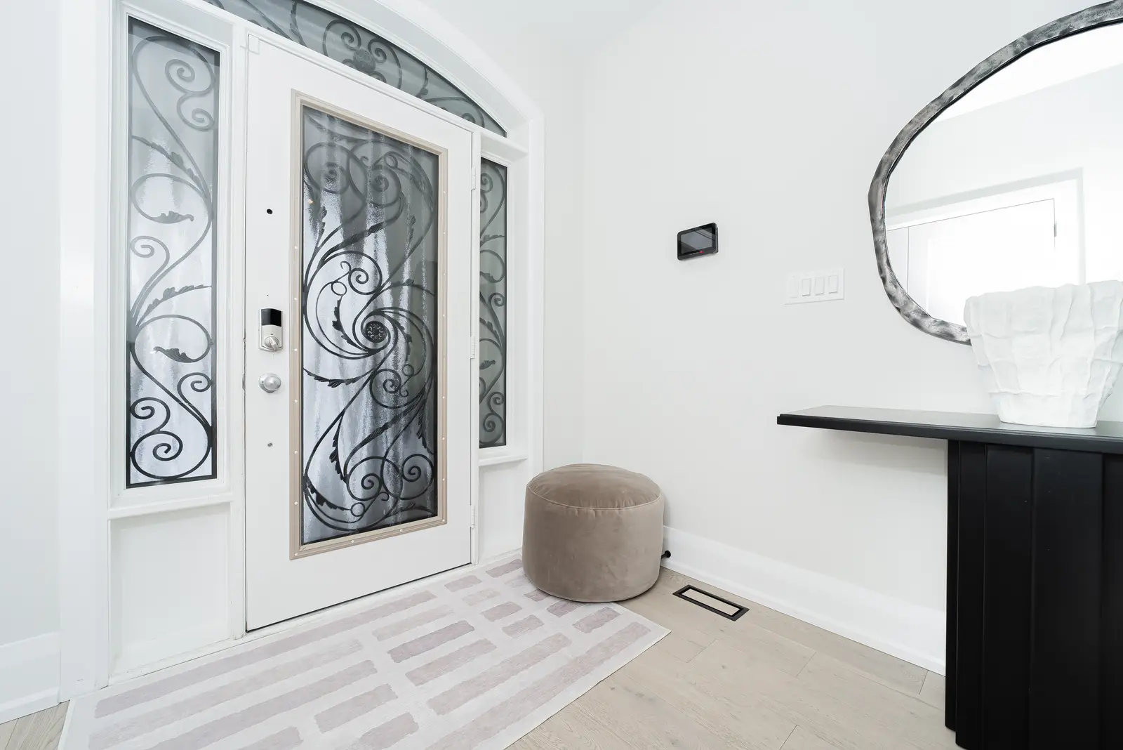 Interior of a Thornhill detached house renovation, with pale wood floors, black furnishings, and a walnut vanity in the primary bathroom.