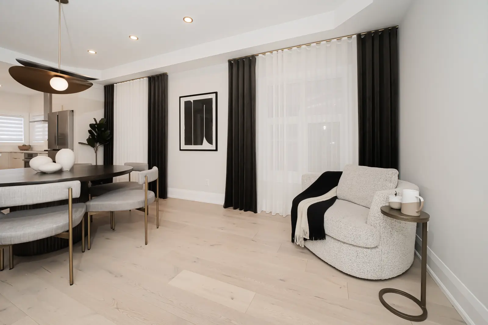 Interior of a Thornhill detached house renovation, with pale wood floors, black furnishings, and a walnut vanity in the primary bathroom.