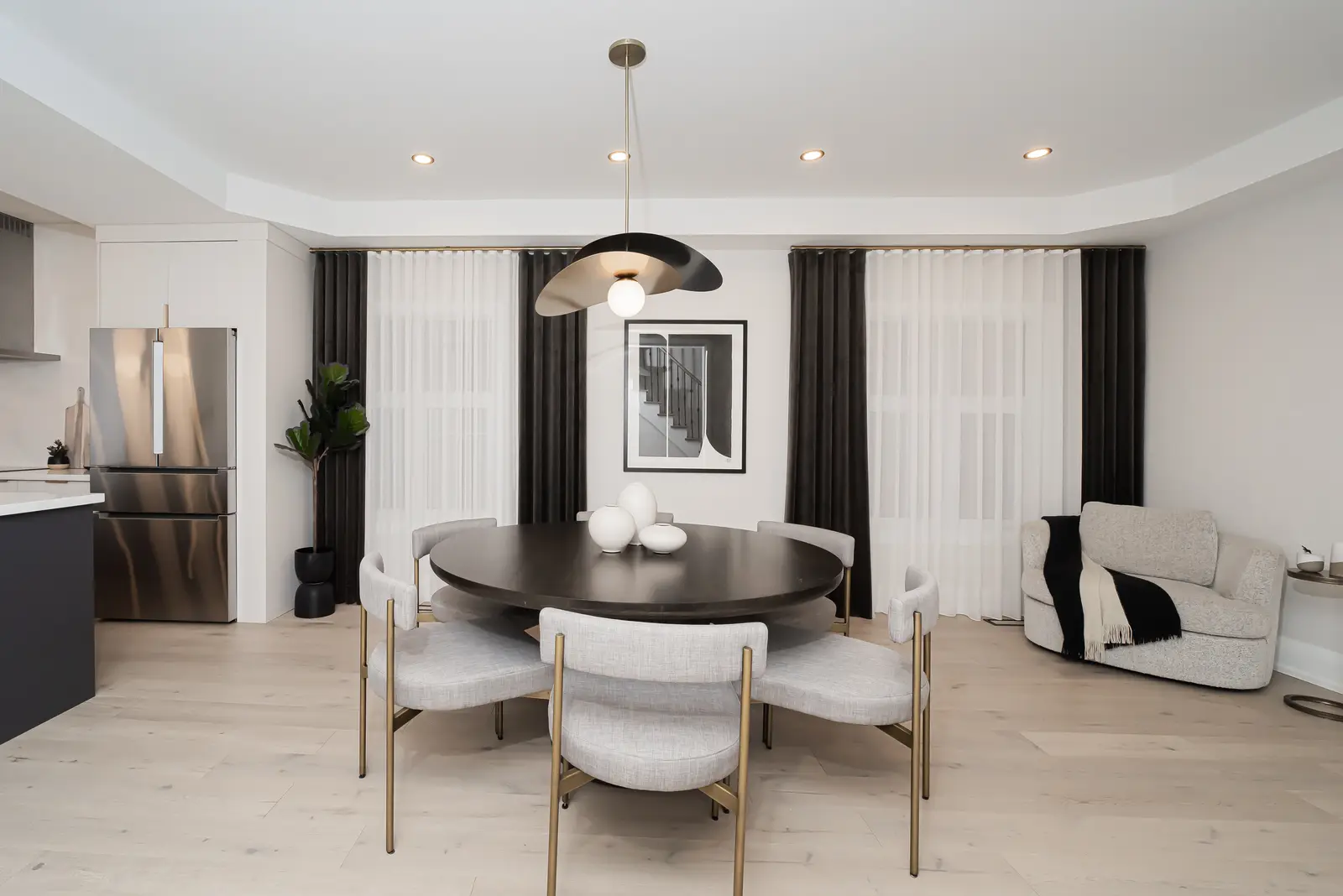Interior of a Thornhill detached house renovation, with pale wood floors, black furnishings, and a walnut vanity in the primary bathroom.