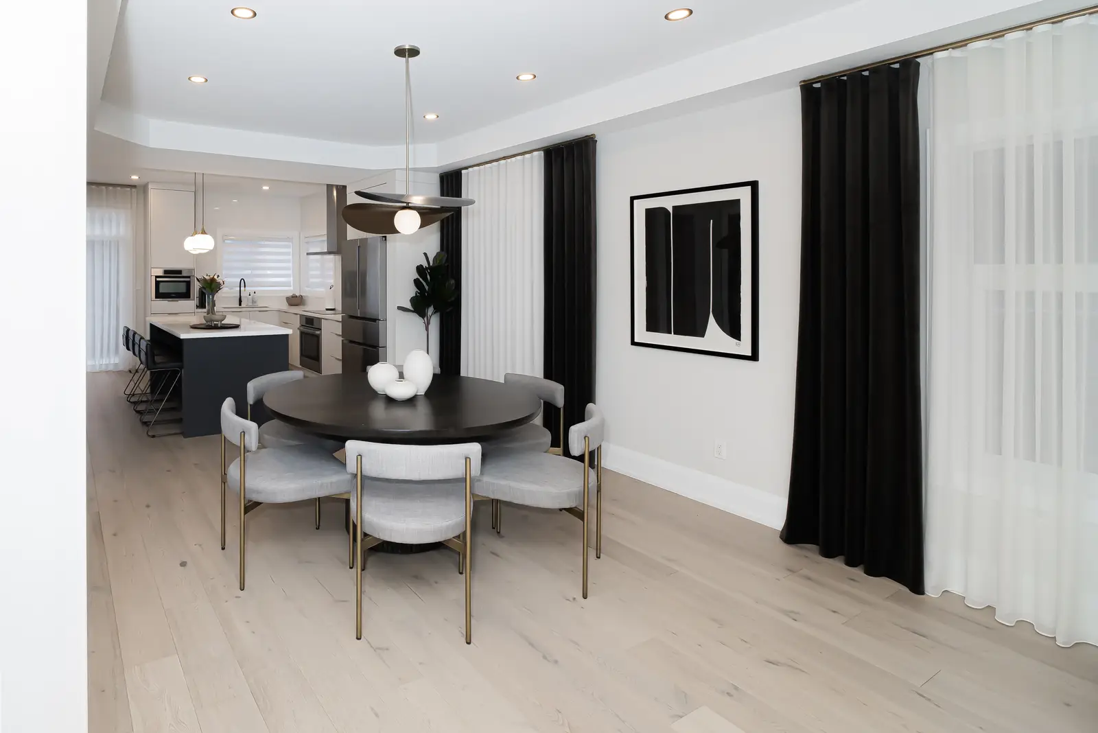 Interior of a Thornhill detached house renovation, with pale wood floors, black furnishings, and a walnut vanity in the primary bathroom.
