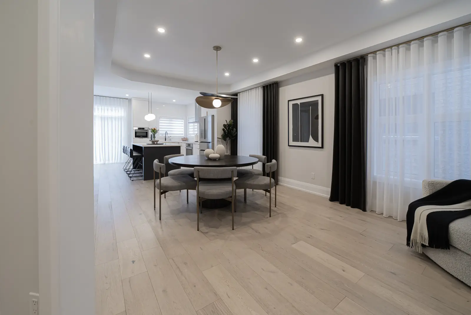 Interior of a Thornhill detached house renovation, with pale wood floors, black furnishings, and a walnut vanity in the primary bathroom.