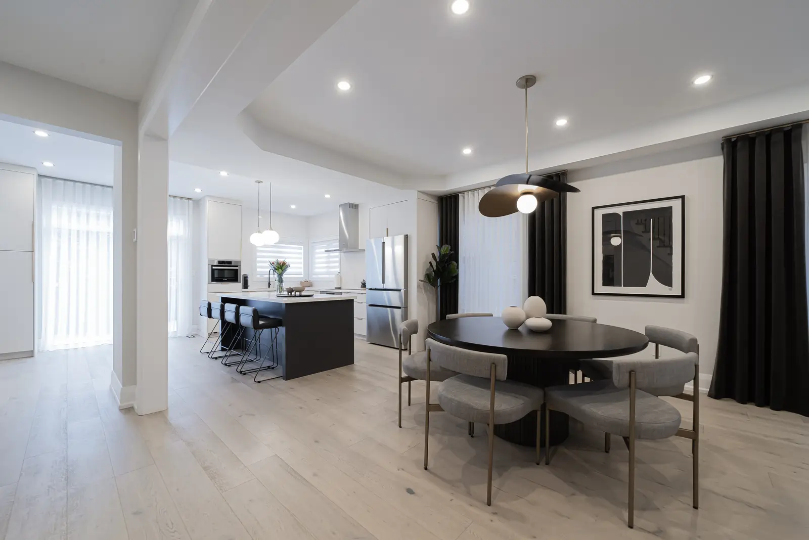 Interior of a Thornhill detached house renovation, with pale wood floors, black furnishings, and a walnut vanity in the primary bathroom.