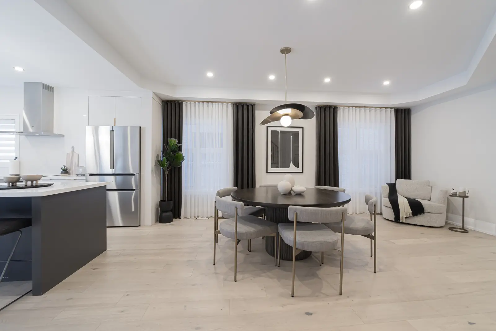 Interior of a Thornhill detached house renovation, with pale wood floors, black furnishings, and a walnut vanity in the primary bathroom.