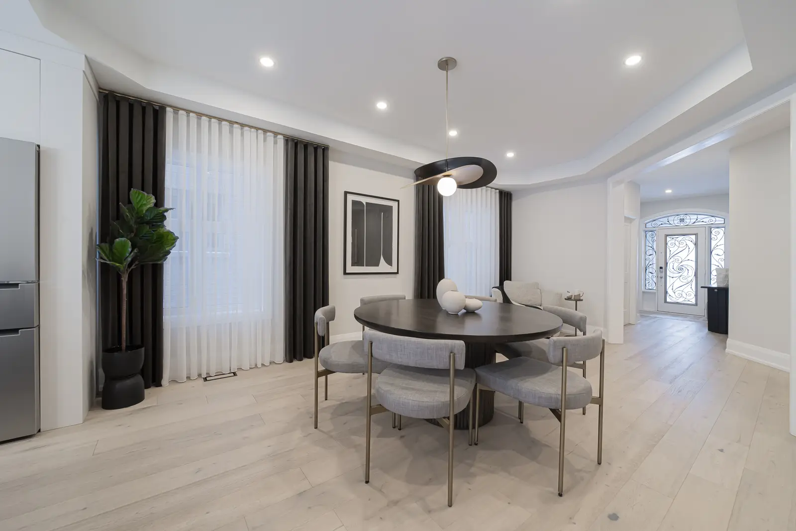 Interior of a Thornhill detached house renovation, with pale wood floors, black furnishings, and a walnut vanity in the primary bathroom.