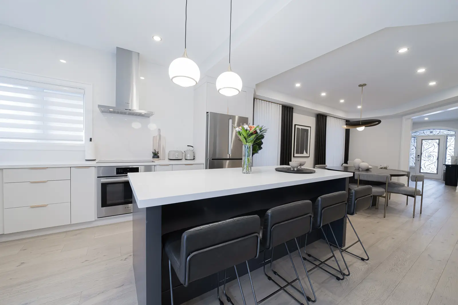 Interior of a Thornhill detached house renovation, with pale wood floors, black furnishings, and a walnut vanity in the primary bathroom.