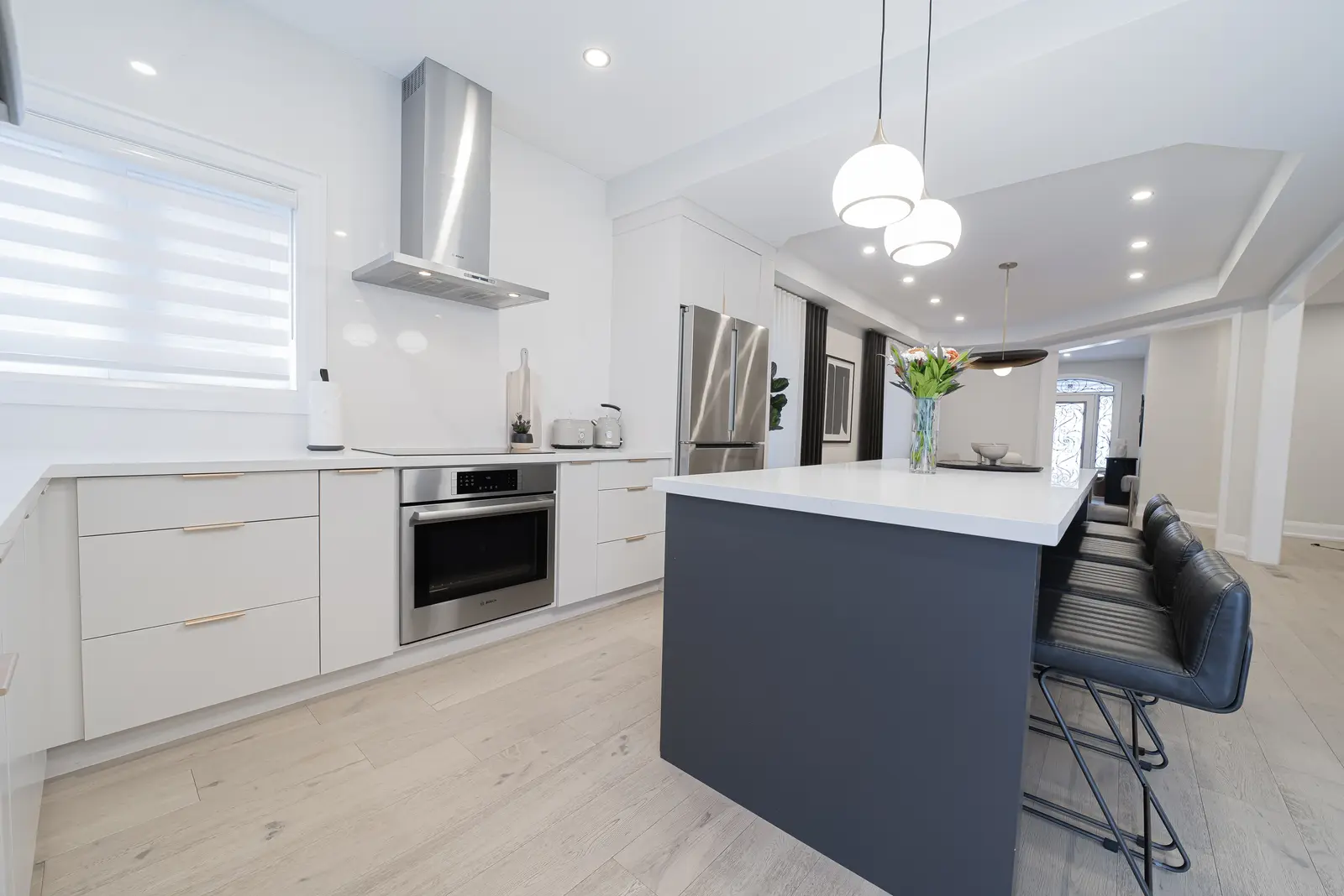 Interior of a Thornhill detached house renovation, with pale wood floors, black furnishings, and a walnut vanity in the primary bathroom.