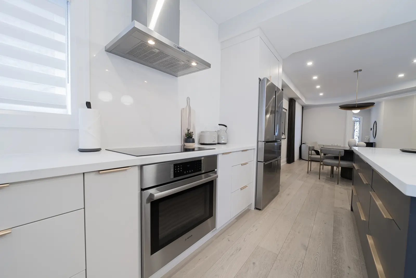 Interior of a Thornhill detached house renovation, with pale wood floors, black furnishings, and a walnut vanity in the primary bathroom.