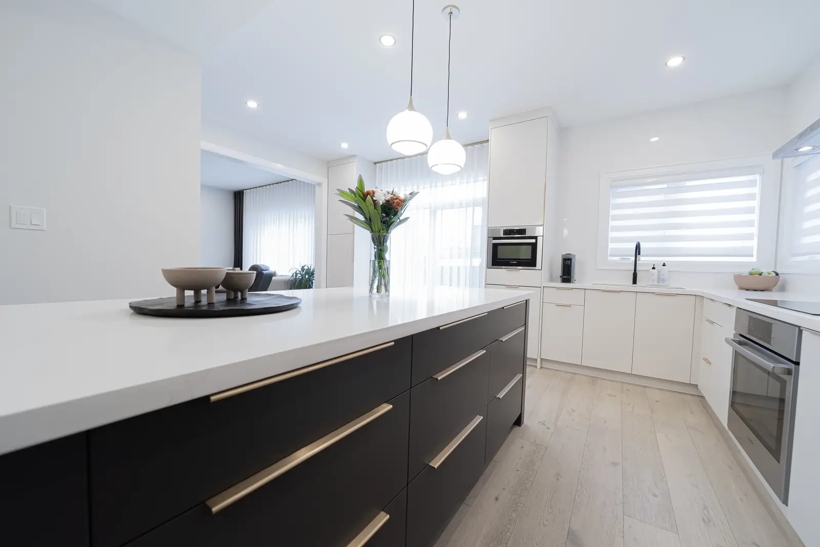 Interior of a Thornhill detached house renovation, with pale wood floors, black furnishings, and a walnut vanity in the primary bathroom.