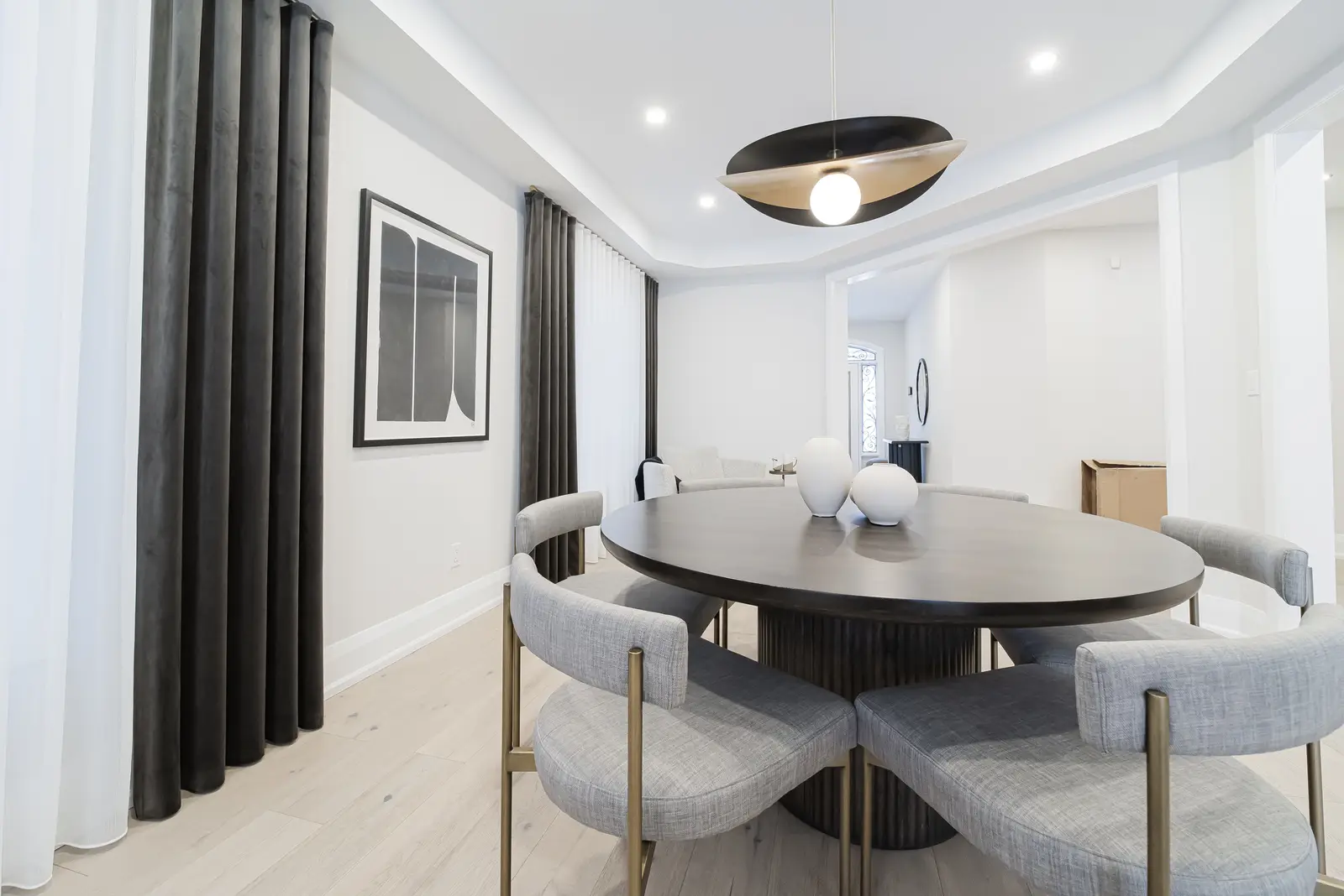 Interior of a Thornhill detached house renovation, with pale wood floors, black furnishings, and a walnut vanity in the primary bathroom.