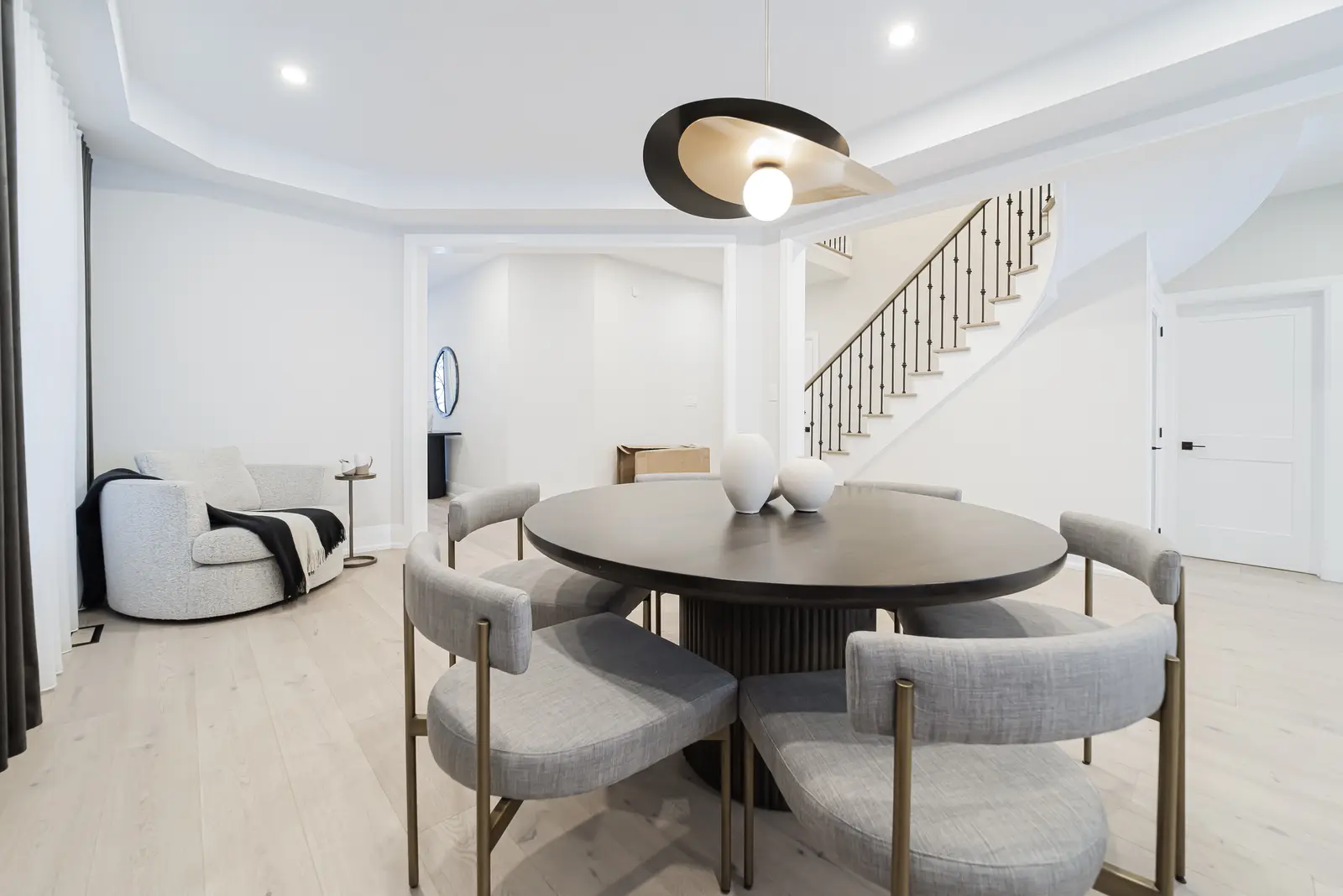 Interior of a Thornhill detached house renovation, with pale wood floors, black furnishings, and a walnut vanity in the primary bathroom.