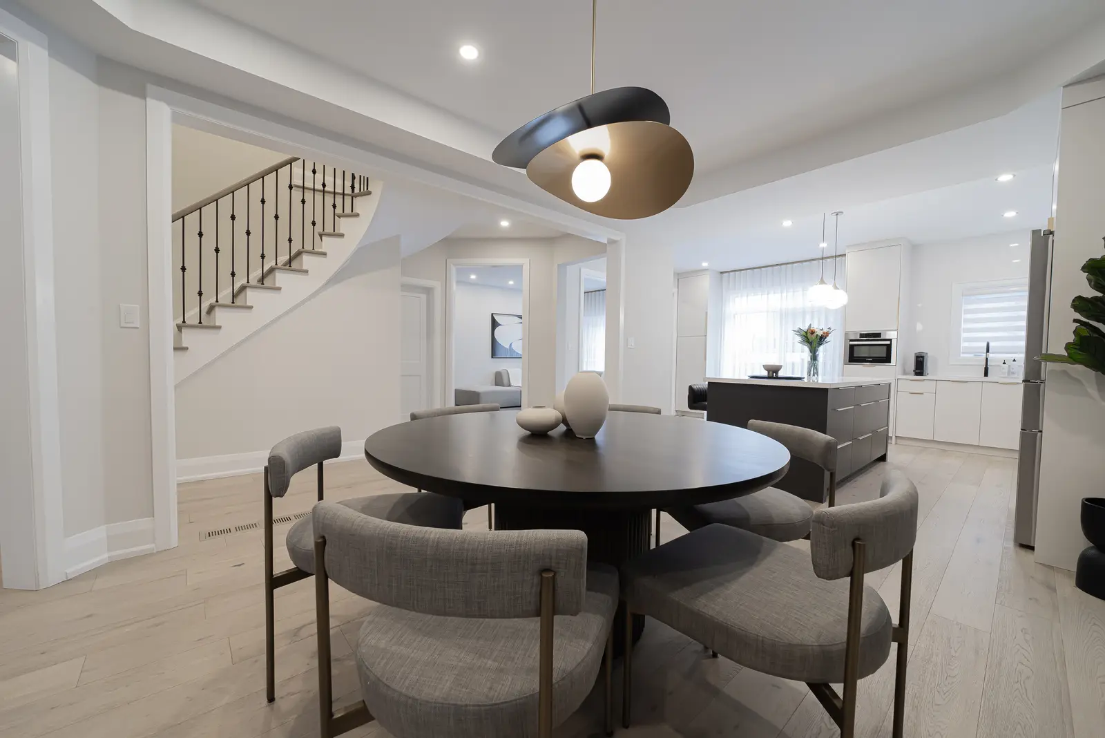 Interior of a Thornhill detached house renovation, with pale wood floors, black furnishings, and a walnut vanity in the primary bathroom.