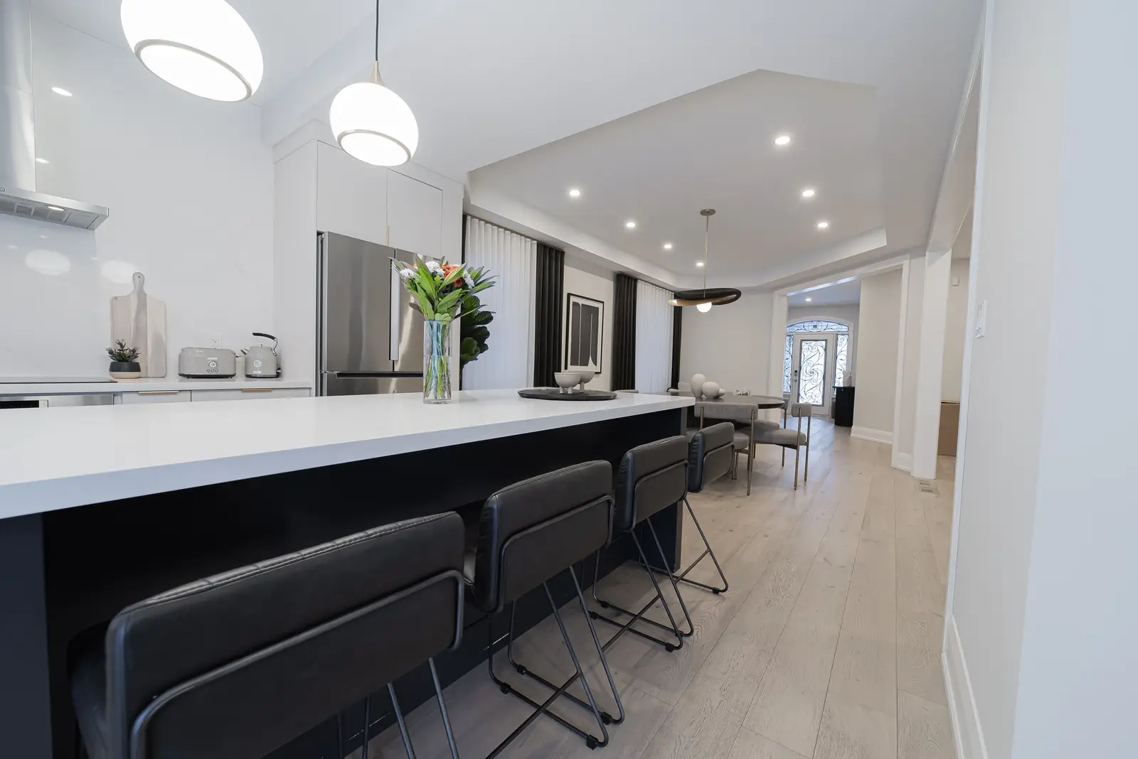Interior of a Thornhill detached house renovation, with pale wood floors, black furnishings, and a walnut vanity in the primary bathroom.
