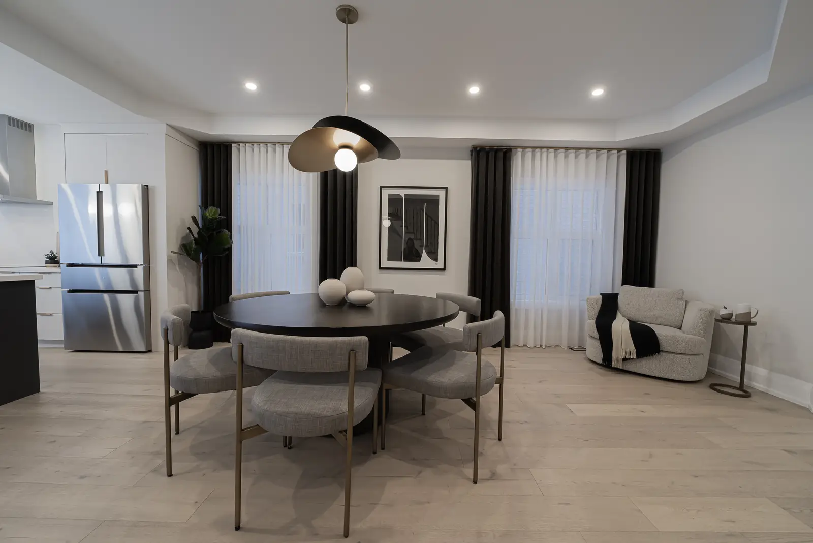 Interior of a Thornhill detached house renovation, with pale wood floors, black furnishings, and a walnut vanity in the primary bathroom.