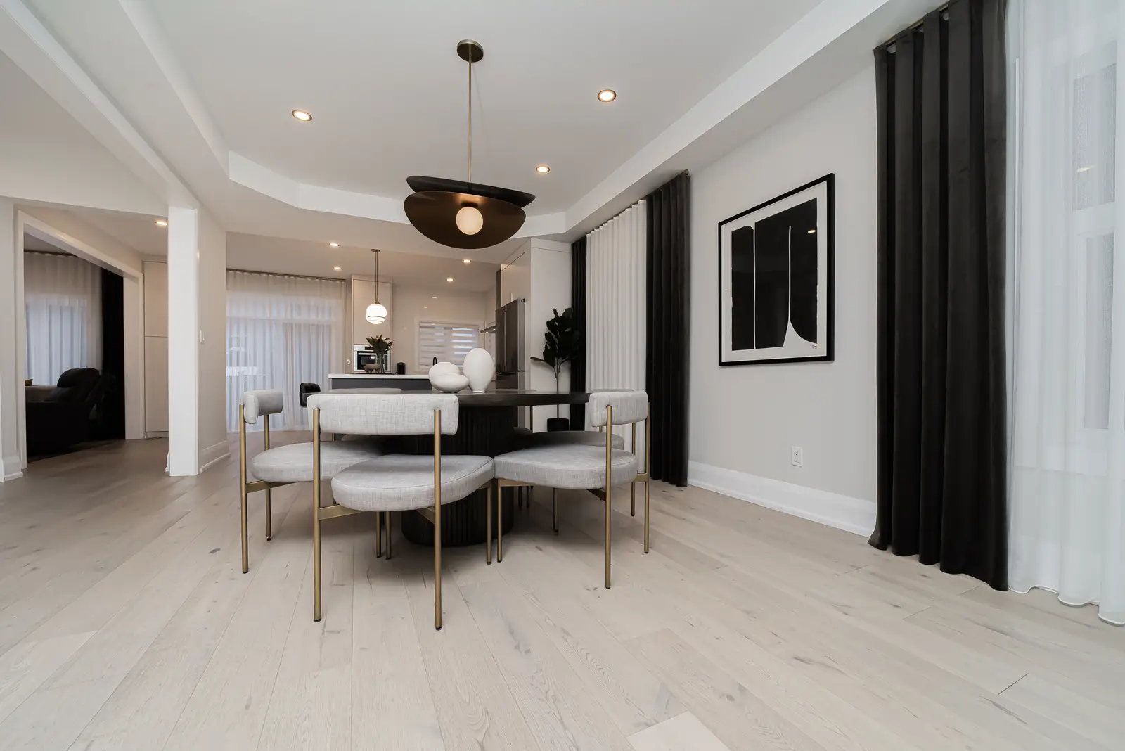 Interior of a Thornhill detached house renovation, with pale wood floors, black furnishings, and a walnut vanity in the primary bathroom.