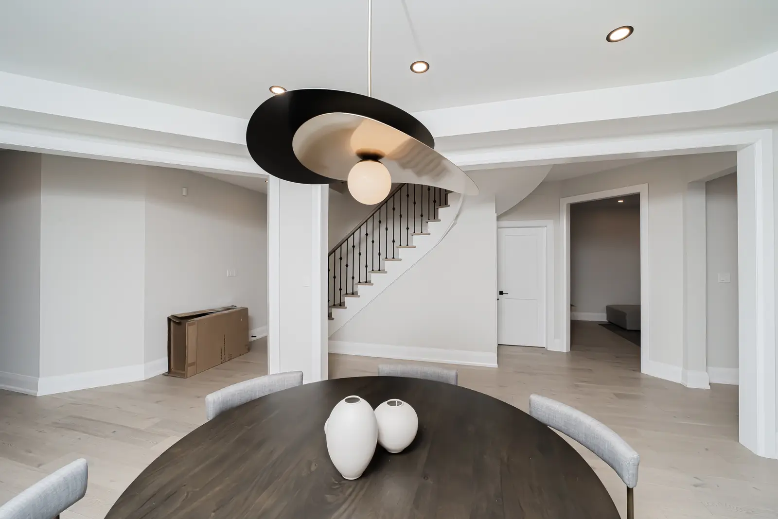Interior of a Thornhill detached house renovation, with pale wood floors, black furnishings, and a walnut vanity in the primary bathroom.