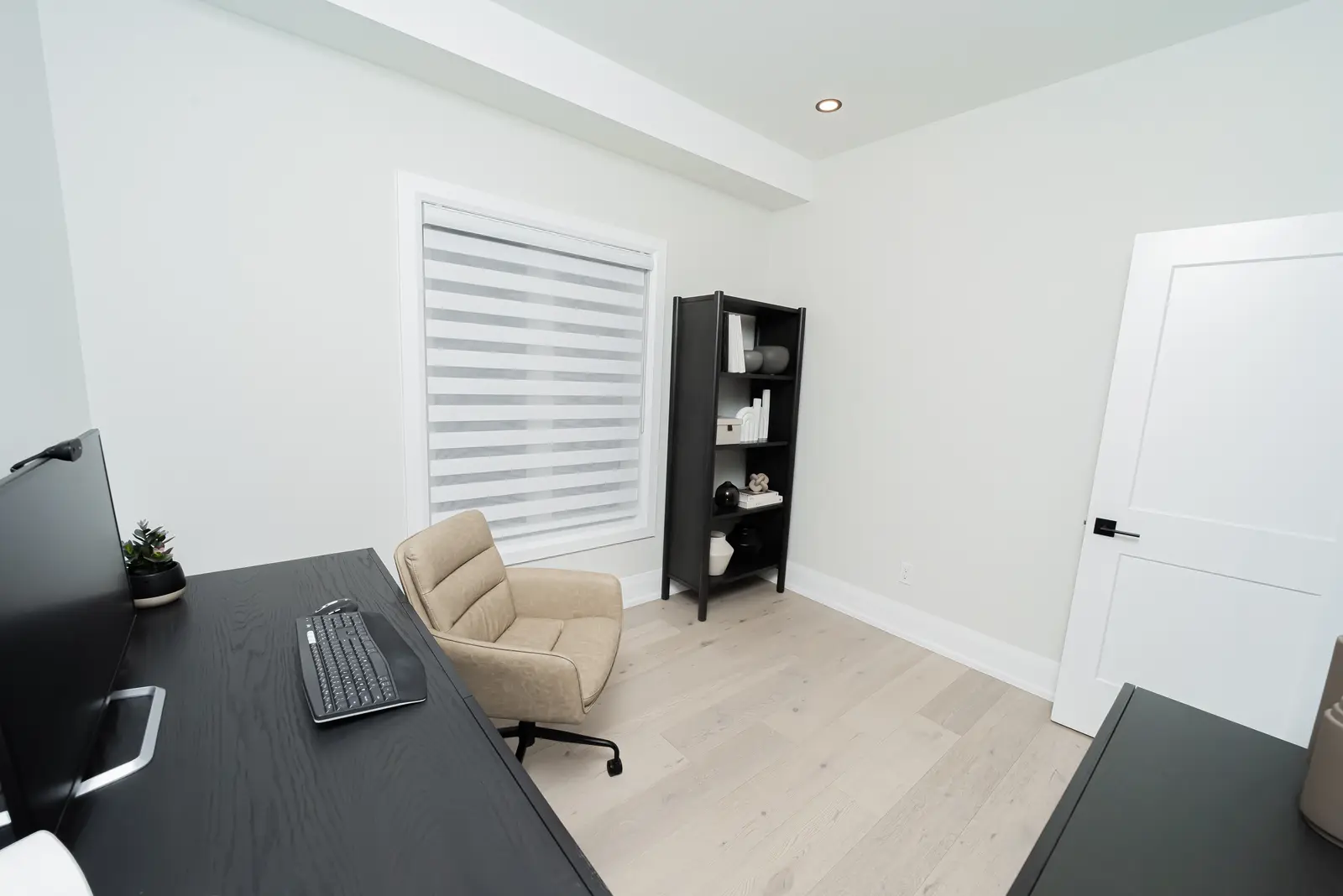Interior of a Thornhill detached house renovation, with pale wood floors, black furnishings, and a walnut vanity in the primary bathroom.