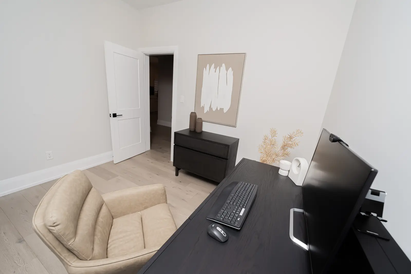 Interior of a Thornhill detached house renovation, with pale wood floors, black furnishings, and a walnut vanity in the primary bathroom.