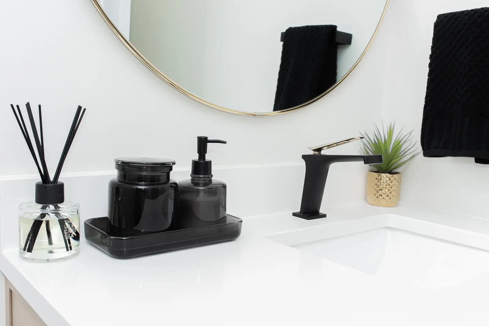 Interior of a Thornhill detached house renovation, with pale wood floors, black furnishings, and a walnut vanity in the primary bathroom.