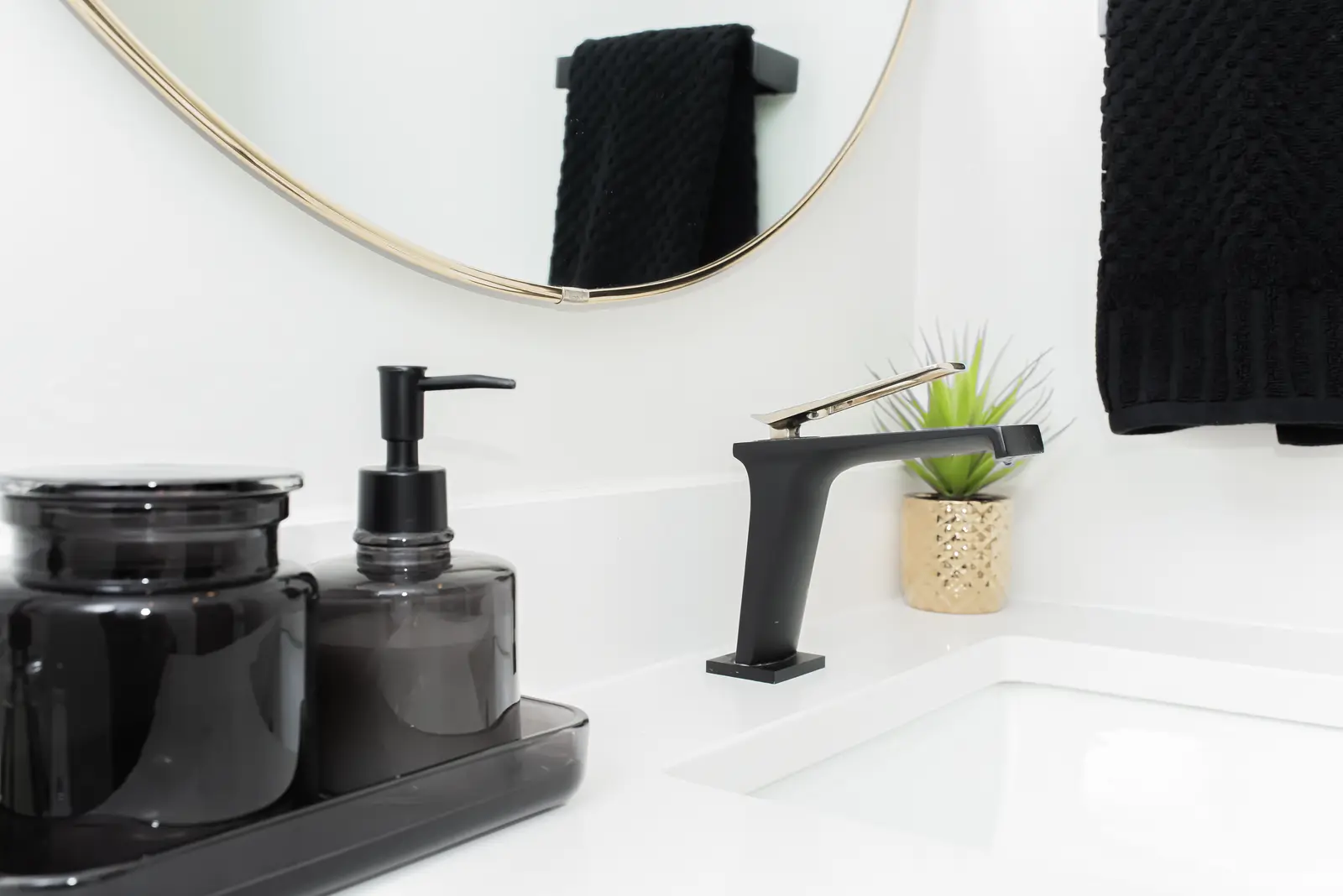 Interior of a Thornhill detached house renovation, with pale wood floors, black furnishings, and a walnut vanity in the primary bathroom.