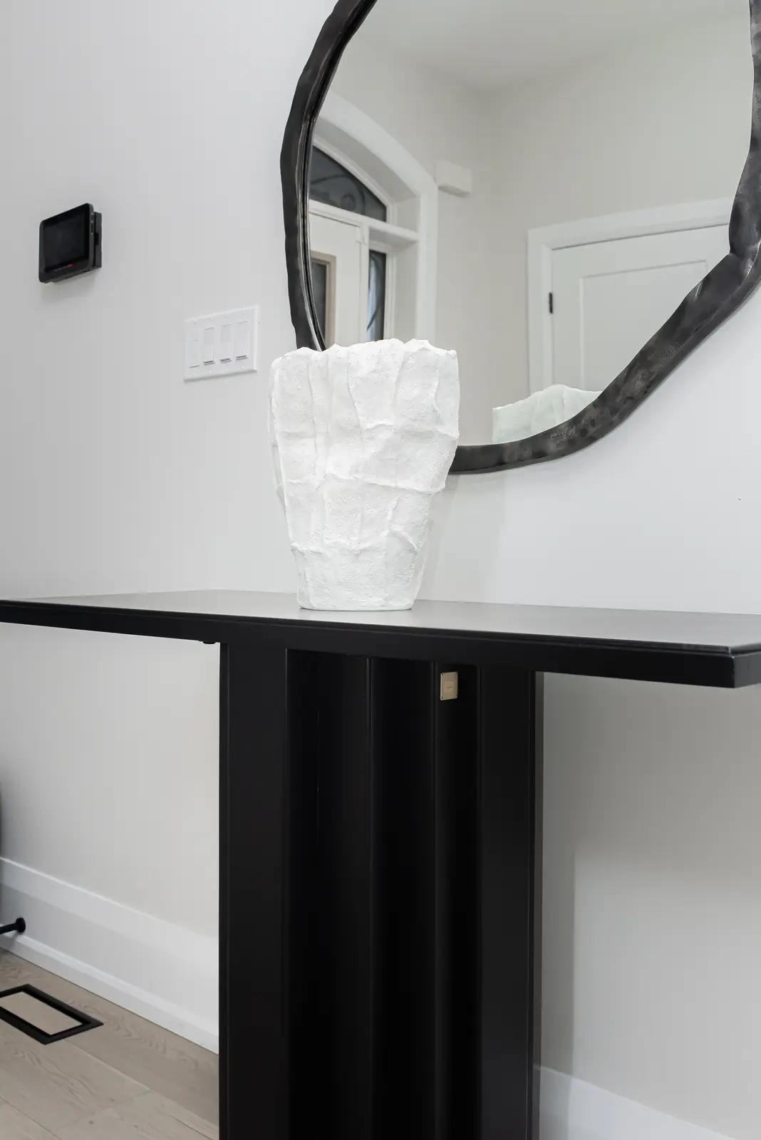 Interior of a Thornhill detached house renovation, with pale wood floors, black furnishings, and a walnut vanity in the primary bathroom.