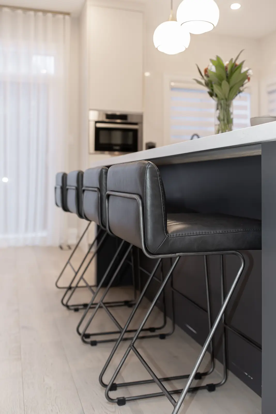 Interior of a Thornhill detached house renovation, with pale wood floors, black furnishings, and a walnut vanity in the primary bathroom.