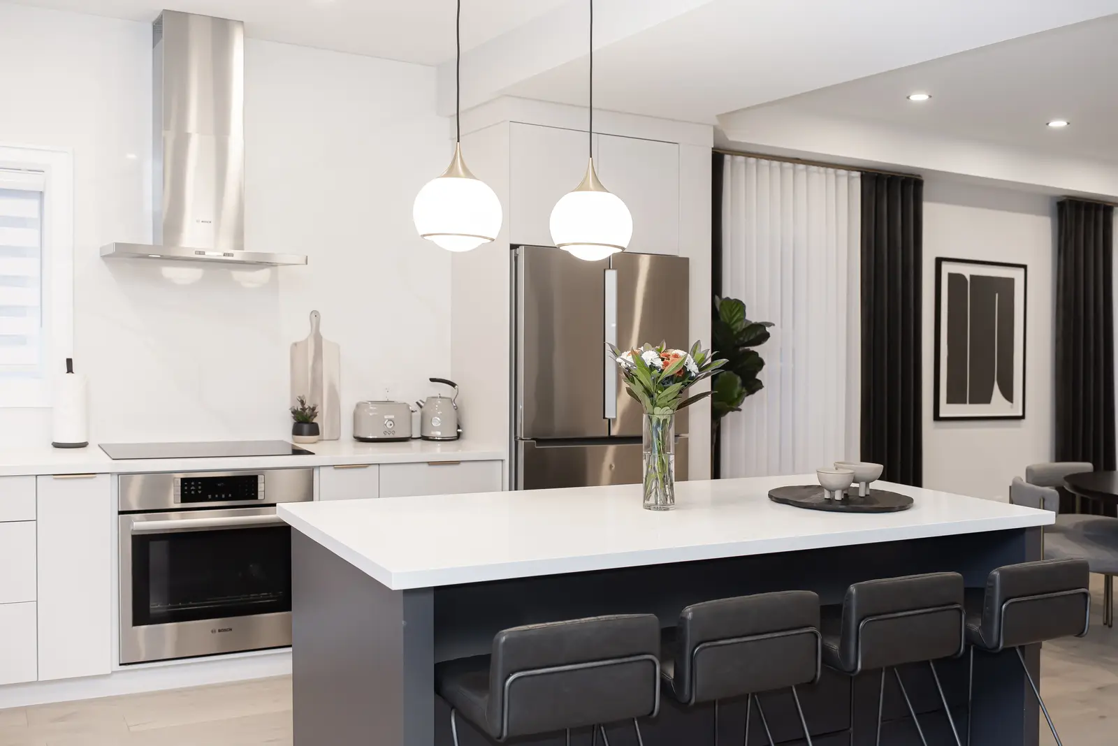 Interior of a Thornhill detached house renovation, with pale wood floors, black furnishings, and a walnut vanity in the primary bathroom.