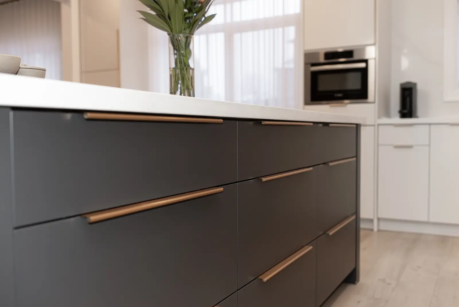 Interior of a Thornhill detached house renovation, with pale wood floors, black furnishings, and a walnut vanity in the primary bathroom.