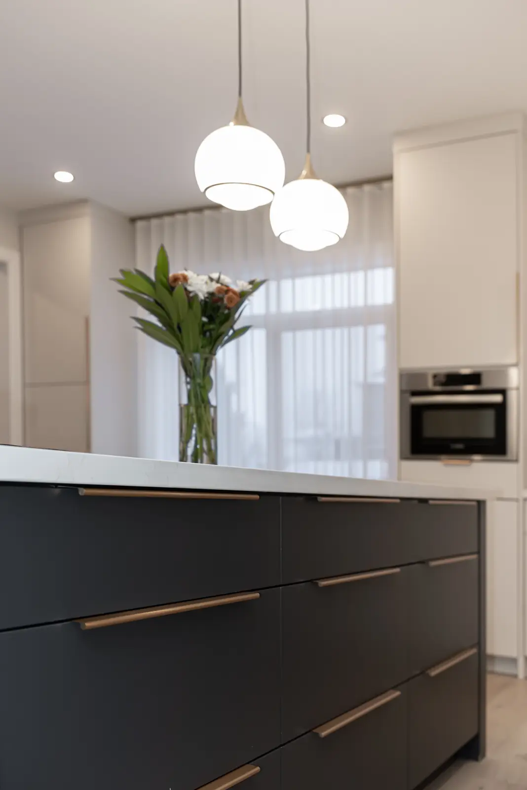 Interior of a Thornhill detached house renovation, with pale wood floors, black furnishings, and a walnut vanity in the primary bathroom.