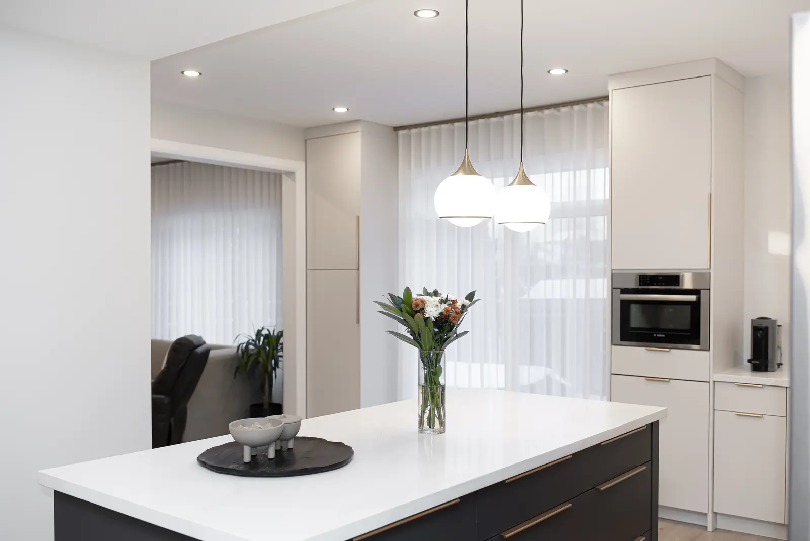 Interior of a Thornhill detached house renovation, with pale wood floors, black furnishings, and a walnut vanity in the primary bathroom.