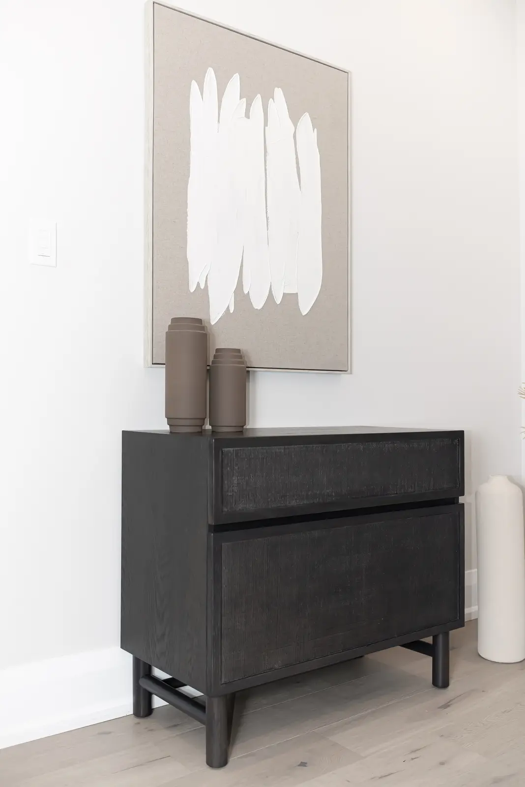 Interior of a Thornhill detached house renovation, with pale wood floors, black furnishings, and a walnut vanity in the primary bathroom.