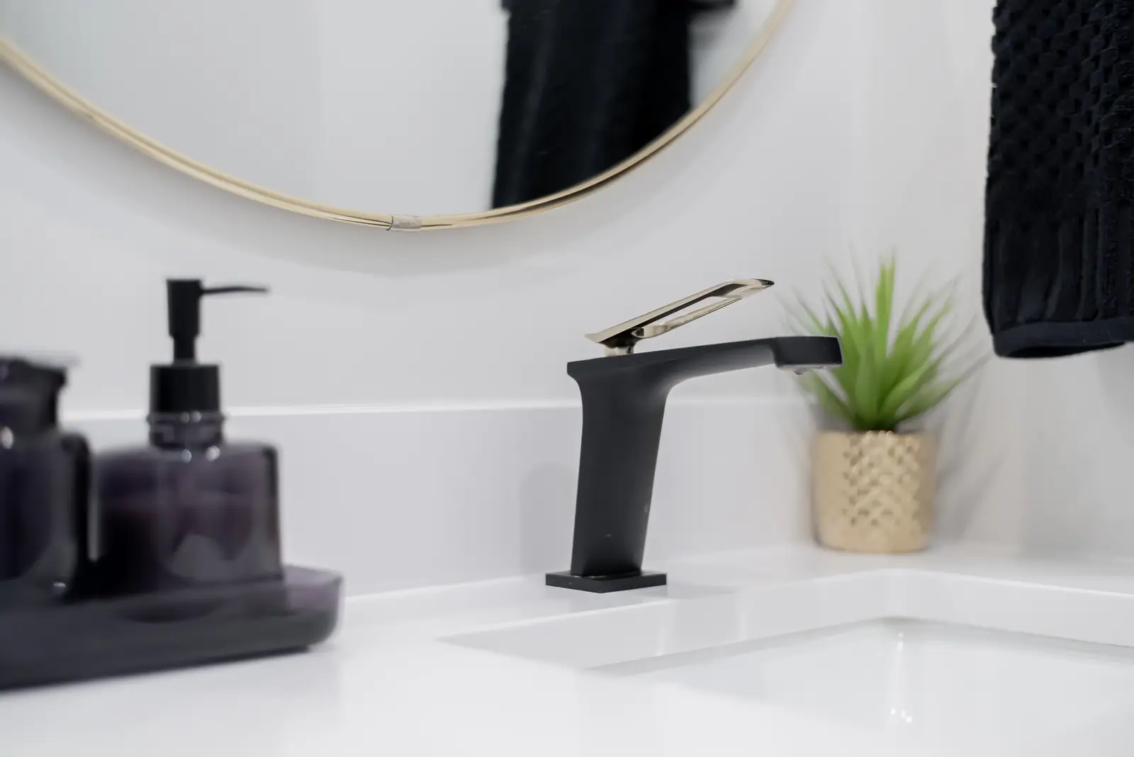 Interior of a Thornhill detached house renovation, with pale wood floors, black furnishings, and a walnut vanity in the primary bathroom.