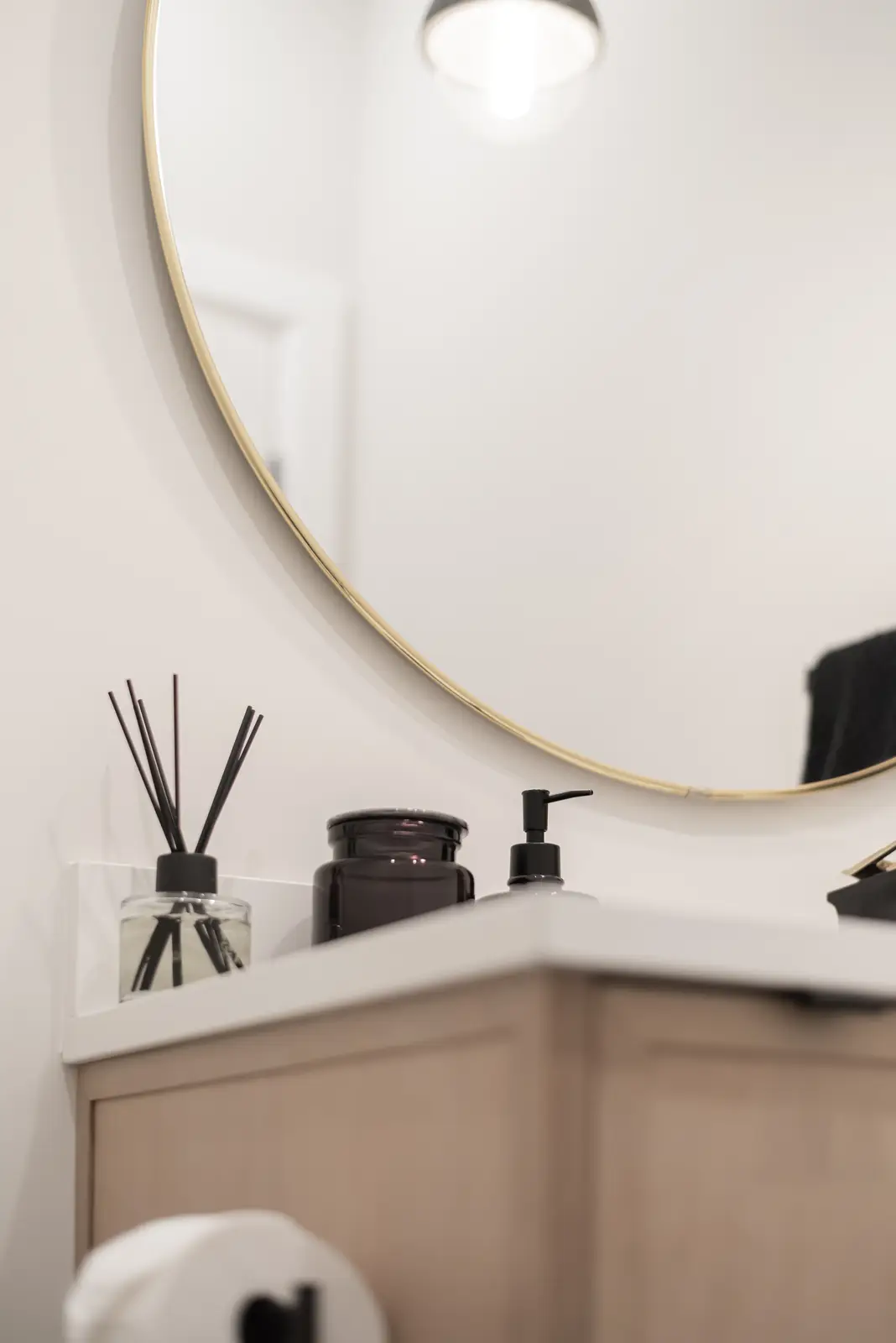 Interior of a Thornhill detached house renovation, with pale wood floors, black furnishings, and a walnut vanity in the primary bathroom.