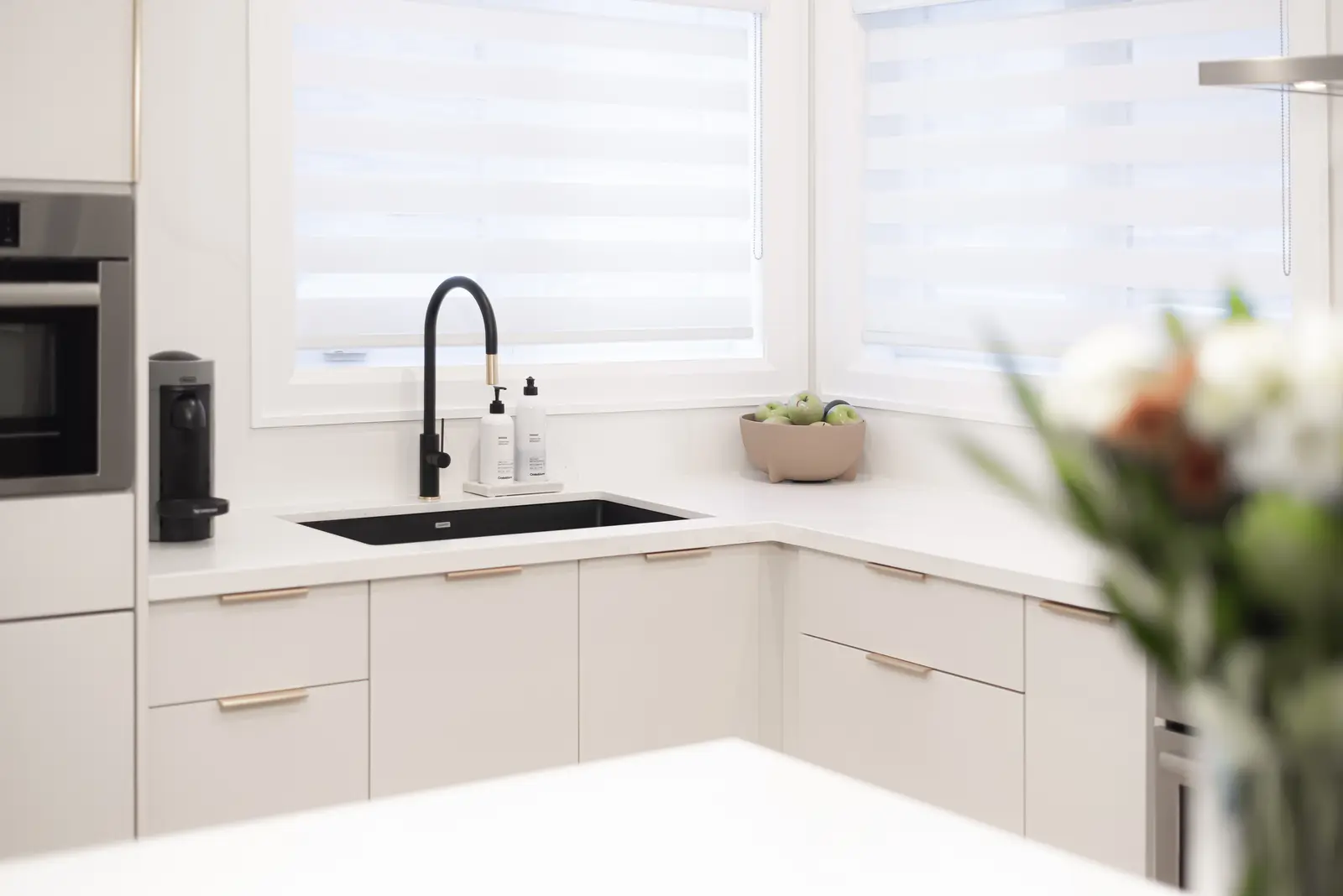 Interior of a Thornhill detached house renovation, with pale wood floors, black furnishings, and a walnut vanity in the primary bathroom.