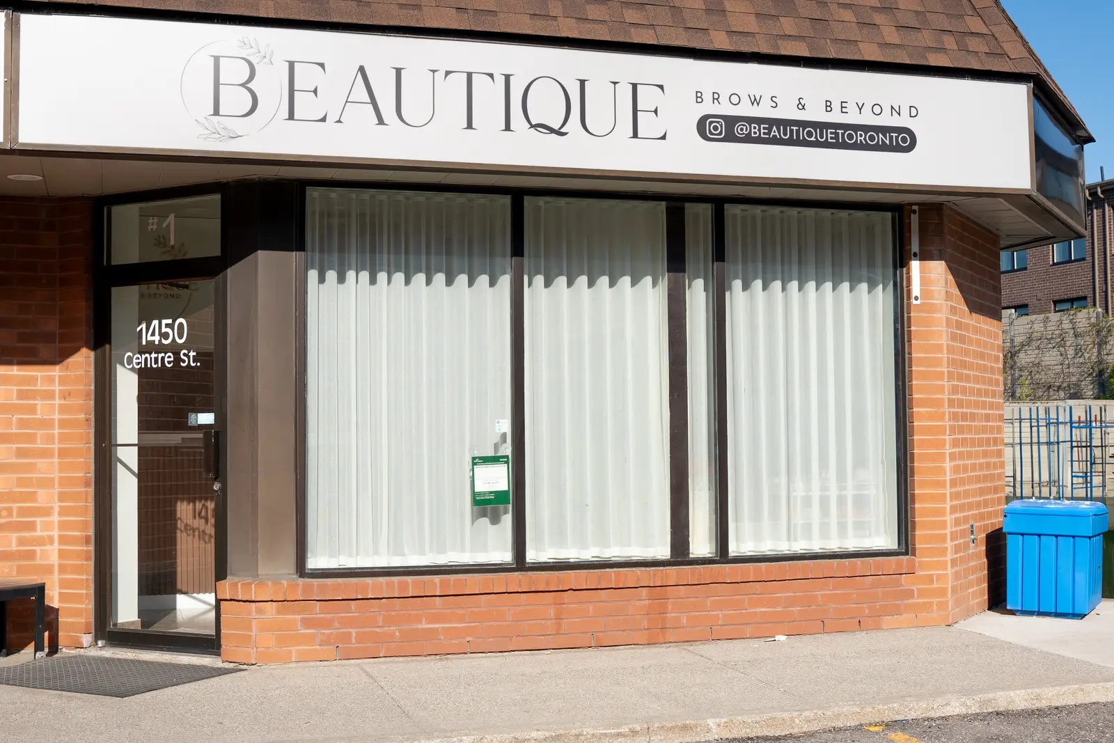 Reception of a Thornhill salon, with a fluted wood desk, a white counter, and a gold Beautique logo.