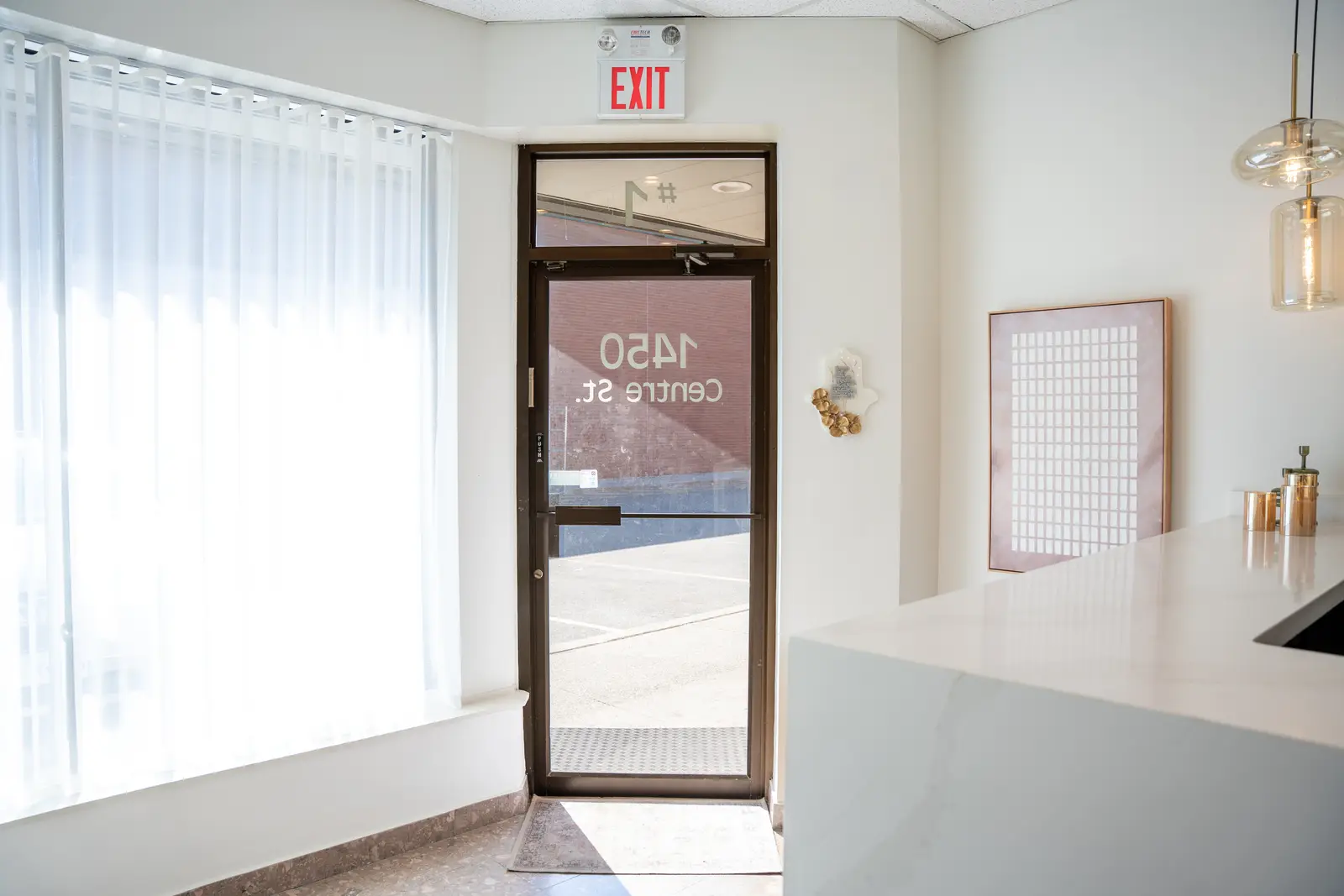 Reception of a Thornhill salon, with a fluted wood desk, a white counter, and a gold Beautique logo.