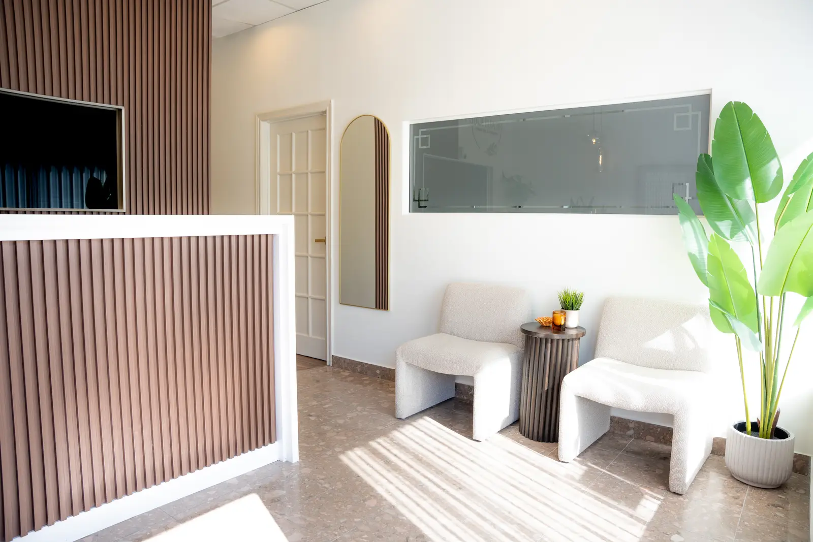 Reception of a Thornhill salon, with a fluted wood desk, a white counter, and a gold Beautique logo.
