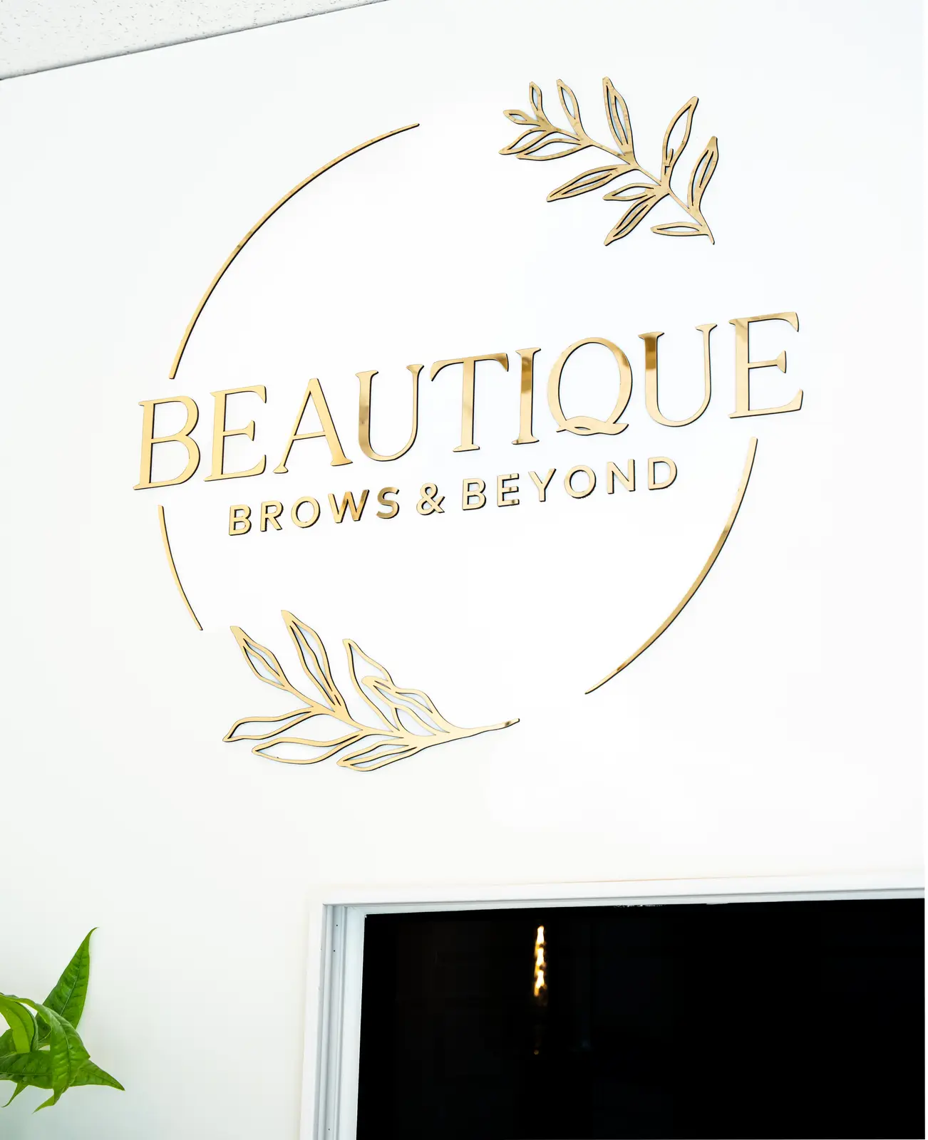 Reception of a Thornhill salon, with a fluted wood desk, a white counter, and a gold Beautique logo.