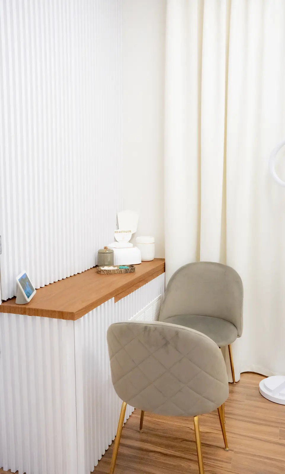 Reception of a Thornhill salon, with a fluted wood desk, a white counter, and a gold Beautique logo.