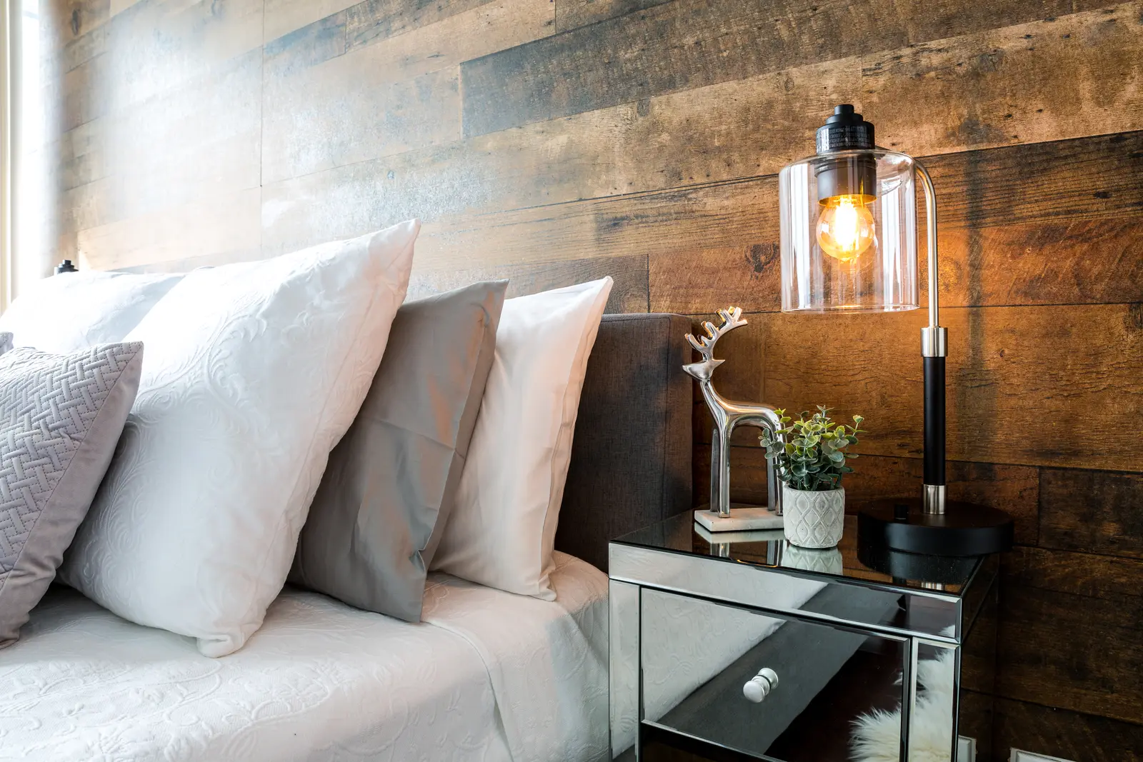 Interior of a Bay Street condo in Toronto, with a grey sofa, a dark kitchen, and city windows.