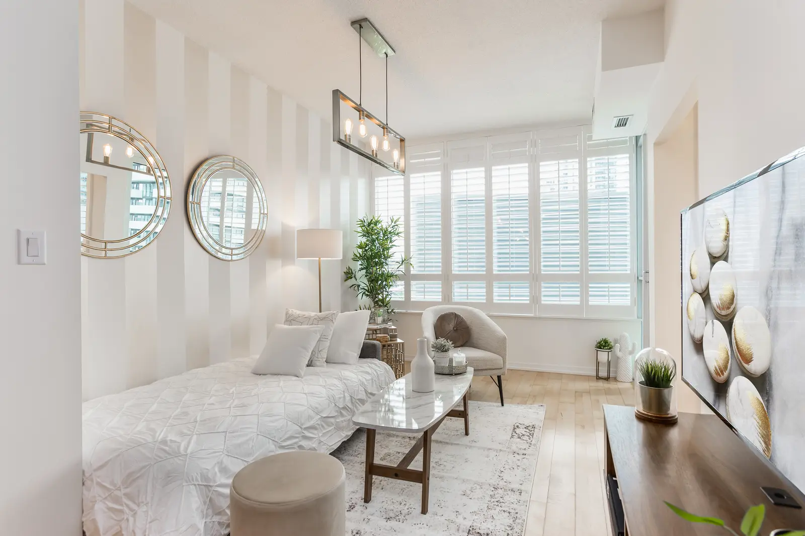 Interior of a downtown Toronto condo, with a wood kitchen, a grey sofa, and a balcony.