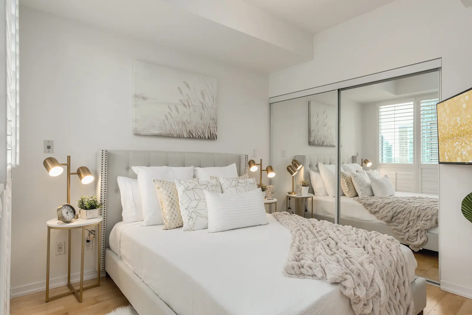 Interior of a downtown Toronto condo, with a wood kitchen, a grey sofa, and a balcony.