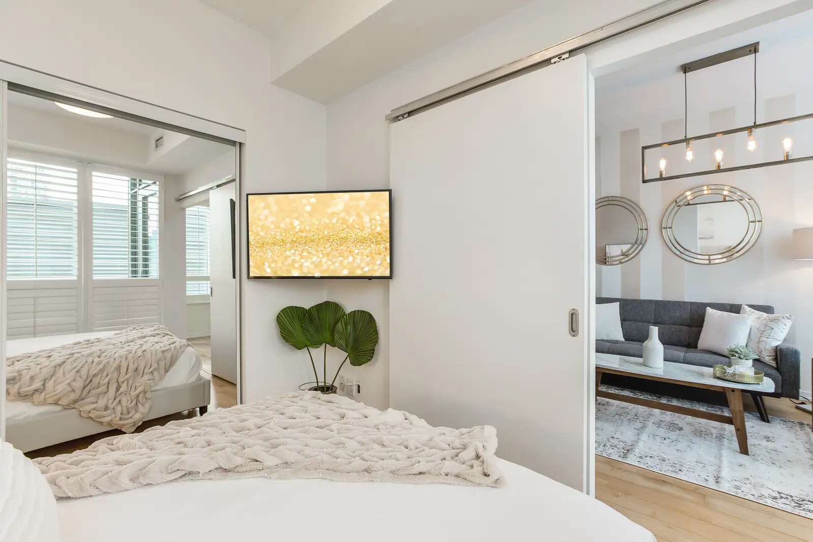 Interior of a downtown Toronto condo, with a wood kitchen, a grey sofa, and a balcony.