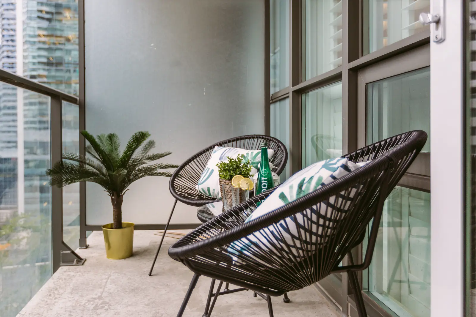 Interior of a downtown Toronto condo, with a wood kitchen, a grey sofa, and a balcony.