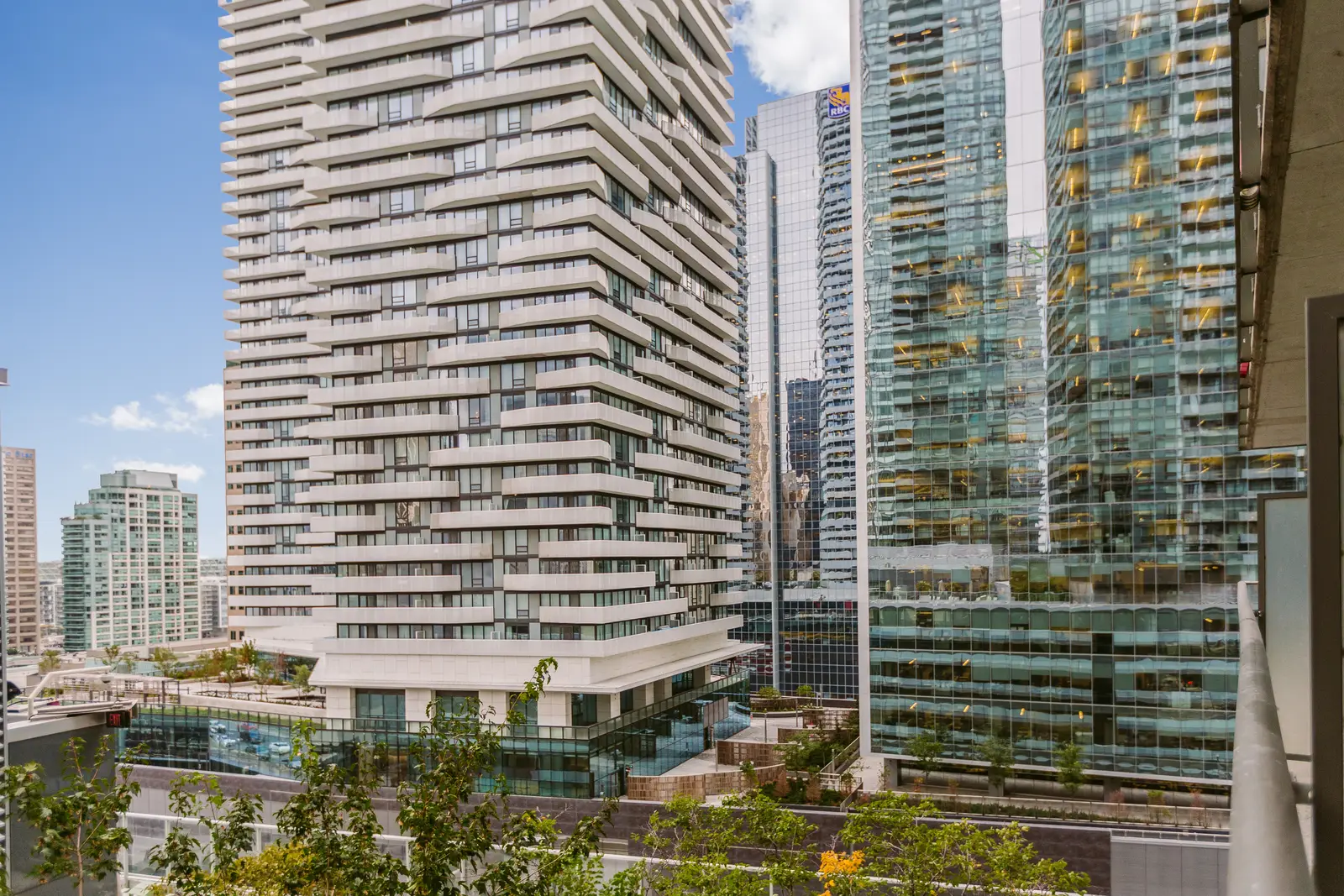 Interior of a downtown Toronto condo, with a wood kitchen, a grey sofa, and a balcony.