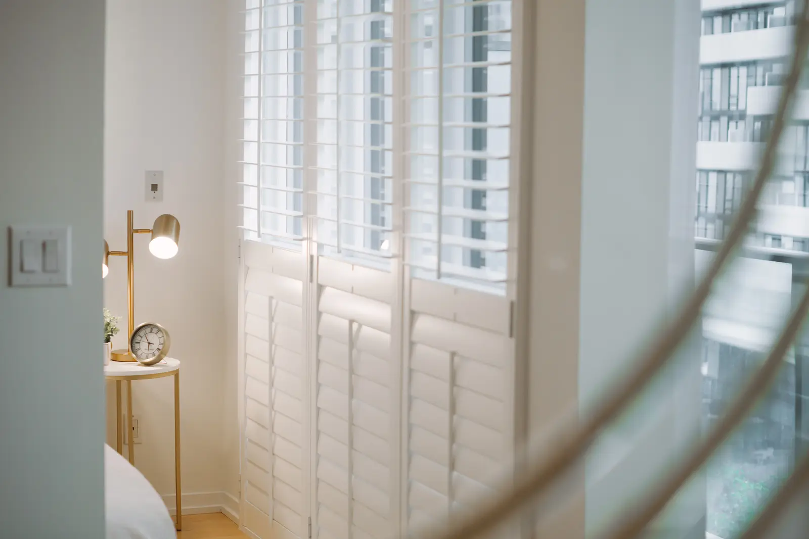 Interior of a downtown Toronto condo, with a wood kitchen, a grey sofa, and a balcony.