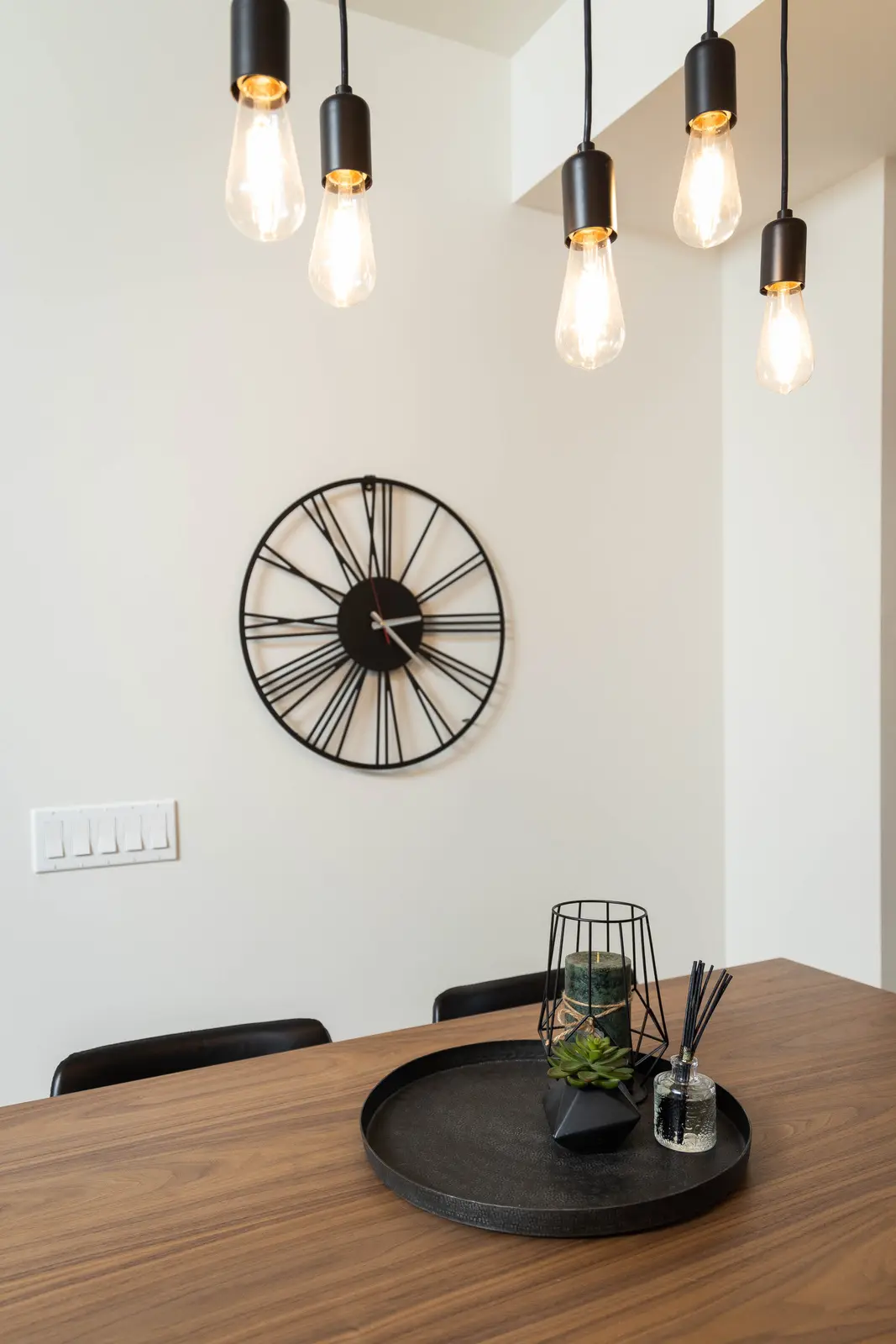 Interior of a Queen West condo in Toronto, with a grey sectional, a white kitchen, and black counters.